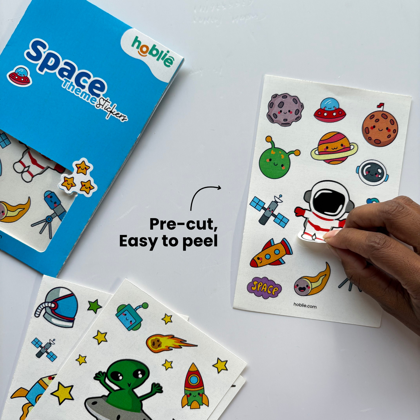 space-themed stickers with a hand picking up a sticker.
