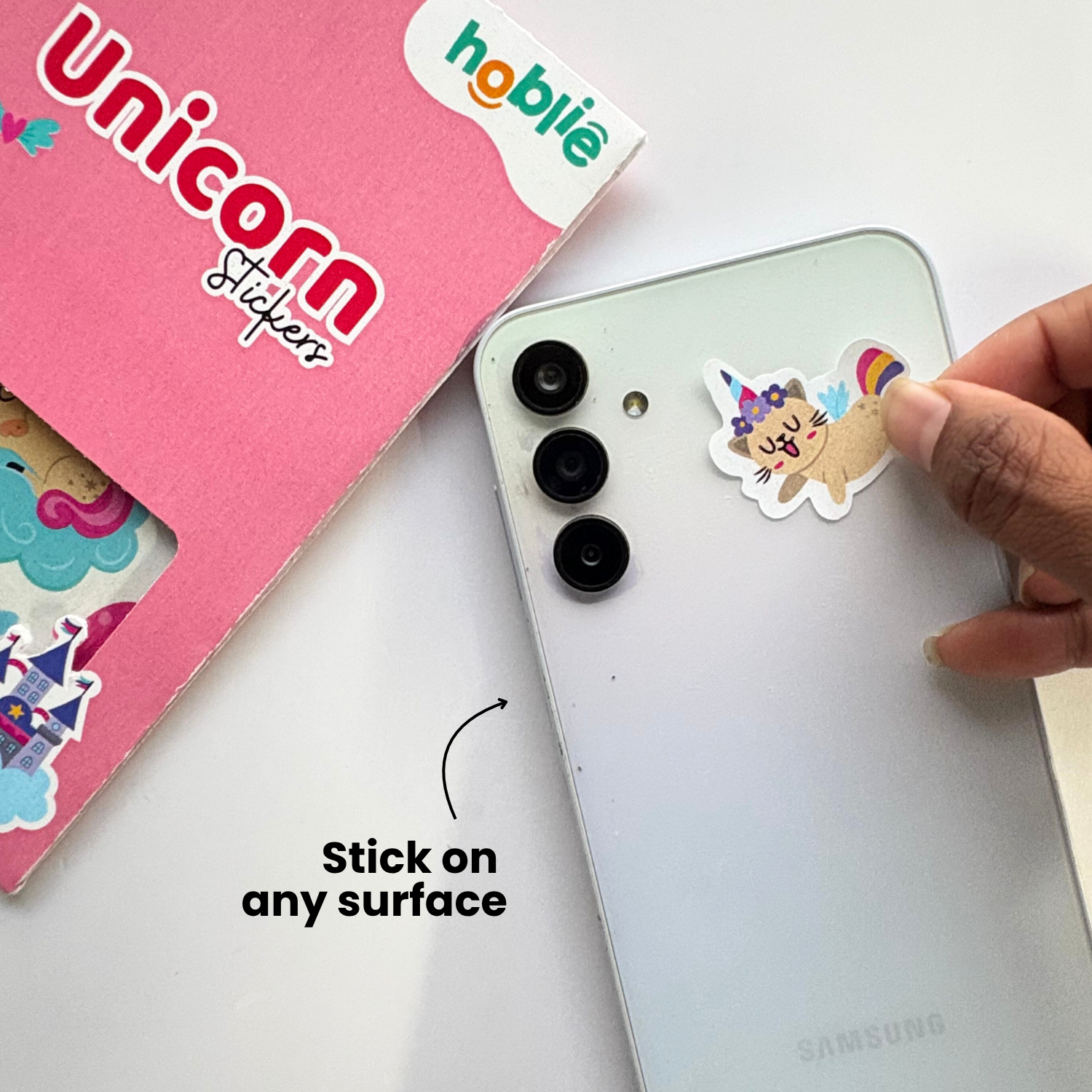 Person applying a cat unicorn sticker to a phone