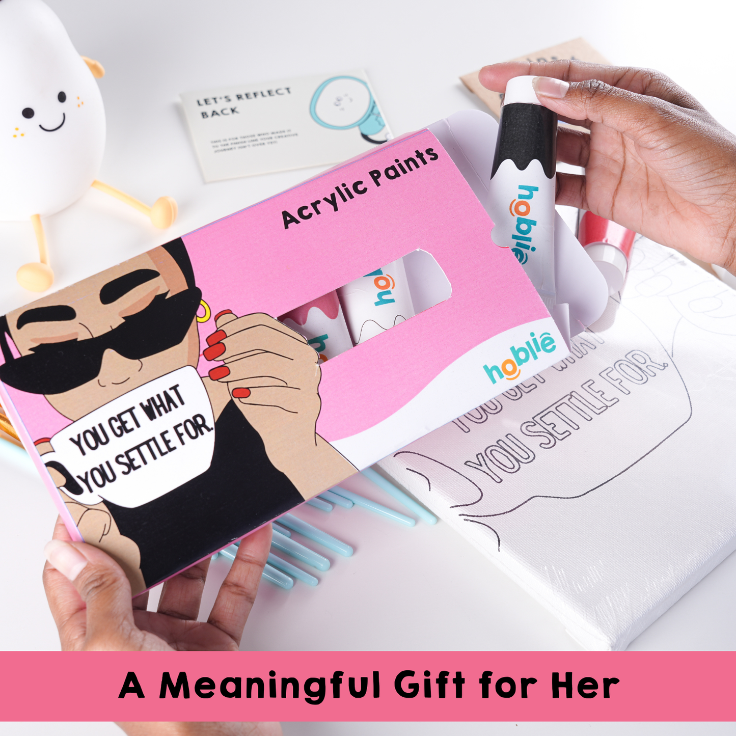 A person is holding an acrylic paint set. The packaging is pink and decorated with a cartoon character, which makes it look fun, playful, and appealing, especially for girls, beginners, or anyone who enjoys cute, aesthetic art supplies. The hand holding it helps show the size of the product and makes the image feel more real and relatable.